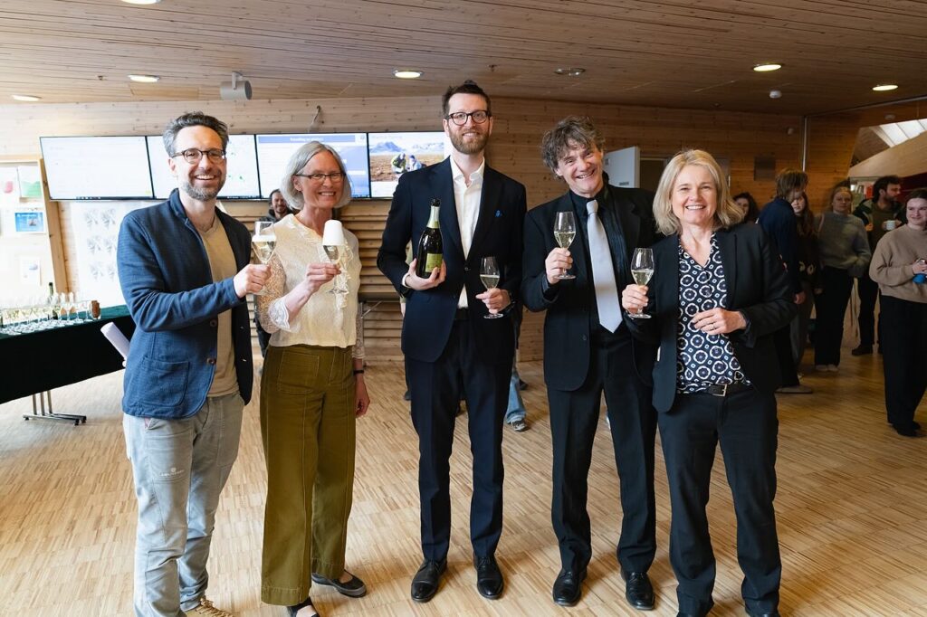 Five people standing holding glasses of champagne, Dr. Flo in the middle